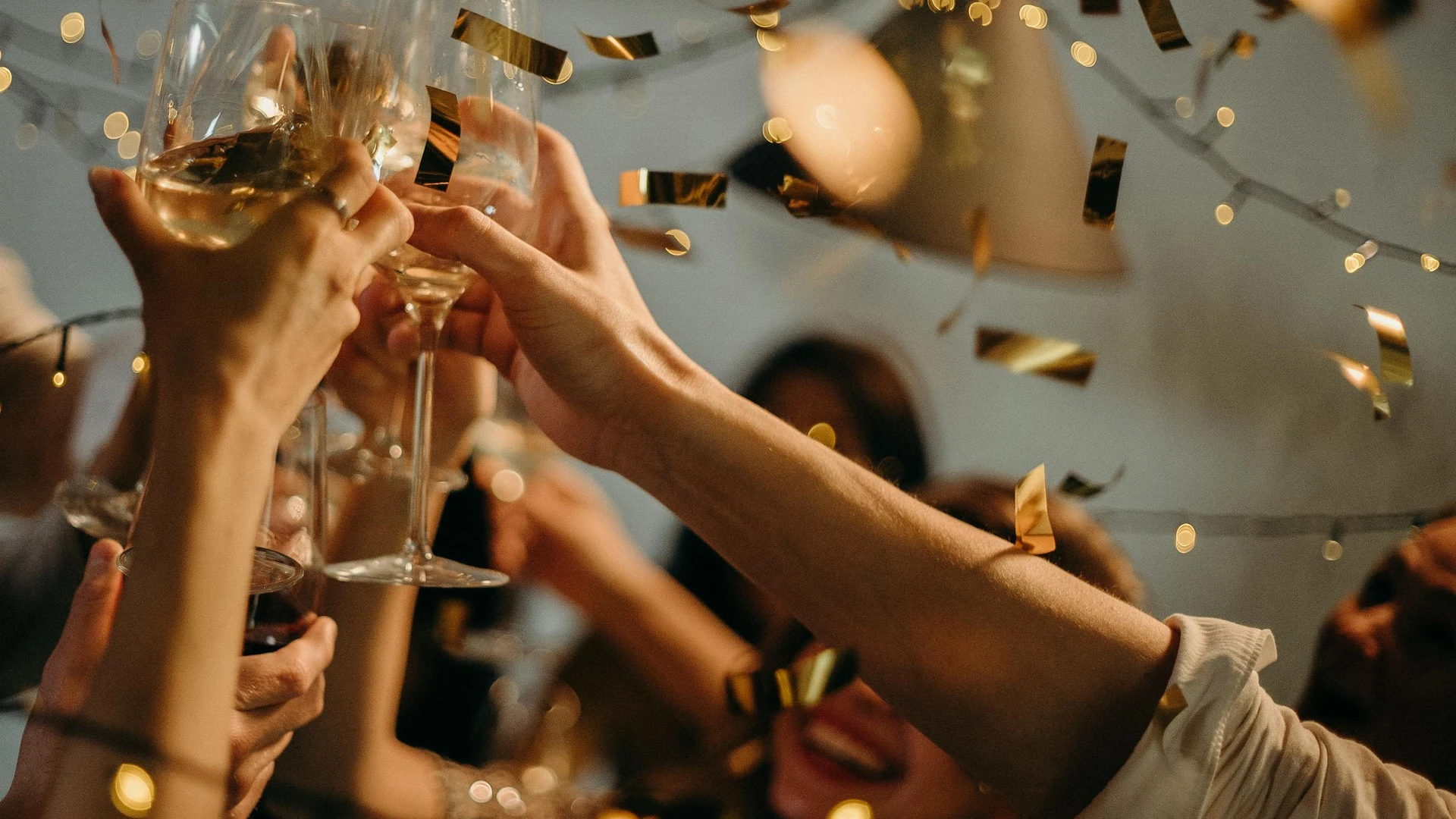 Friends toasting with glasses, warm light—social connection off-screen